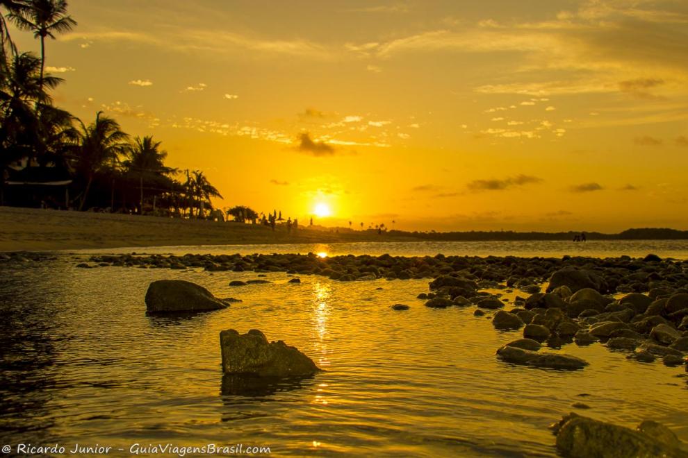 Imagem de pedras no beira do mar e o lindo entardecer-Praia da Boca da Barra.